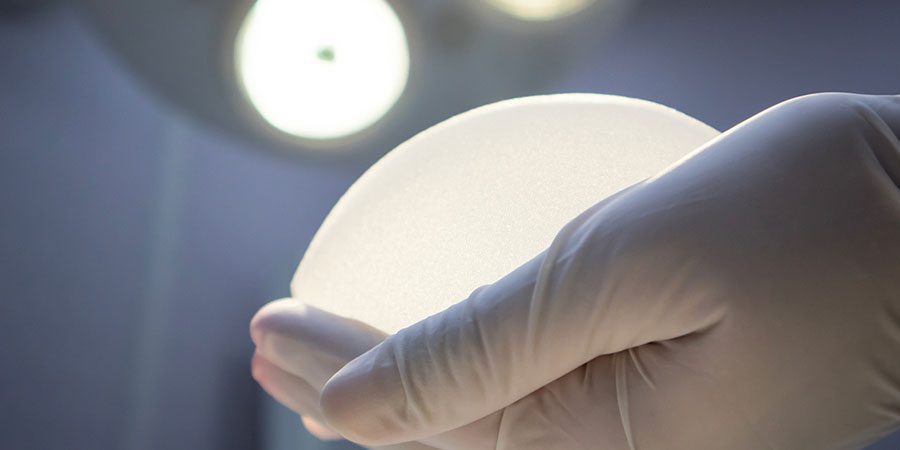 breast implant in surgeon's gloved hand